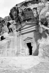 Tomb dug into a red mountainside of Little Petra.