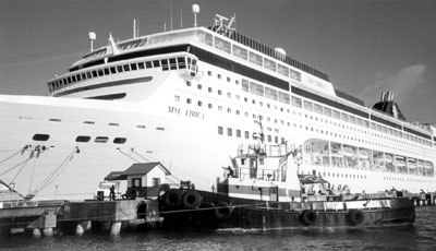 The MSC Lirica towers over a tug in Puerto Limón, Costa Rica. Photos: Palic