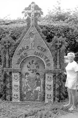 Margaret Dear beside a typical well dressing in Derbyshire.