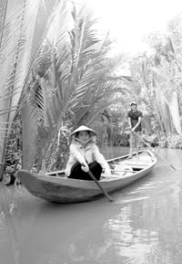 Local villagers navigating a narrow tributary of the My Tho River. 