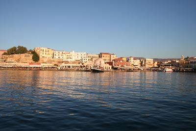 Rays from a setting sun light the skyline along the port of Hania, Crete.