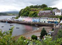 Portree, the largest town on the Isle of Skye, is nestled deep in its protective harbor, where colorful homes look out over bobbing boats and the surrounding peninsulas. Photo by Dominic Arizona Bonuccelli