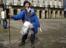 A jubilant pilgrim on Spain’s Camino de Santiago marks the end of her journey in front of the cathedral in Santiago de Compostela. Photo by Rick Steves