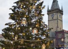 A Christmas market scene in Prague, Czechia, with the Old Town Hall in the background.