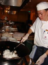 Chef Teng stirring in prawns and squid.