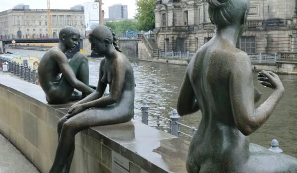 Bronze statues lining the Spree River.