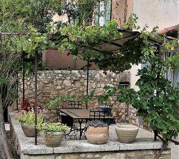 Outdoor patio and grape arbor at the farmhouse in Pernes-les-Fontaines.