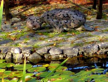 A bronze sculpture of a sleeping woman rests near a pond in the Samhain Winter Garden — Brigit's Garden, County Galway, Ireland. 