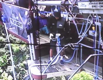 An employee worked on the bungee-jumping harness as Steve Richards sat awaiting his turn. 