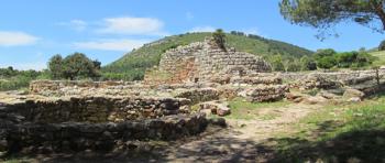 Nuraghe Palmavera, with stone hut bases in the foreground.